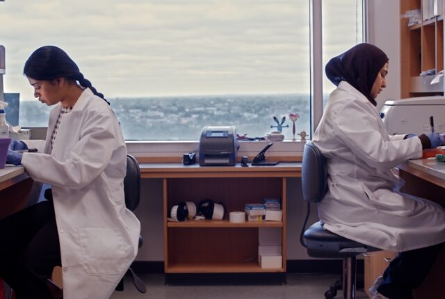 Two biomedical researchers conducting experiments in a laboratory