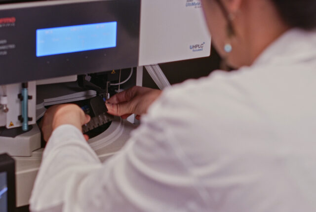 A researcher loading samples into a mass spectrometer