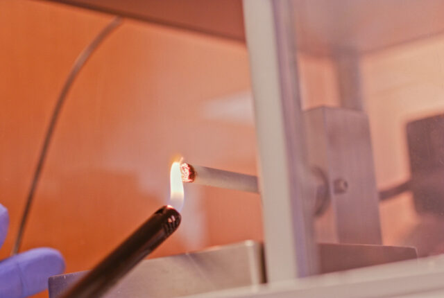 Researcher lighting a cigarette in the smoking machine