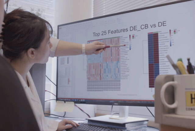 Instructor pointing out data on a computer screen